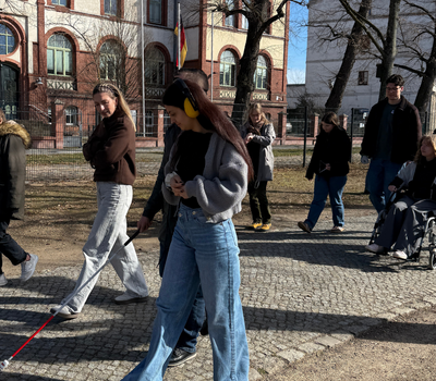 Die Seminarteilnehmer erkunden mittels Rollstuhl und Gehhilfen die Umgebung